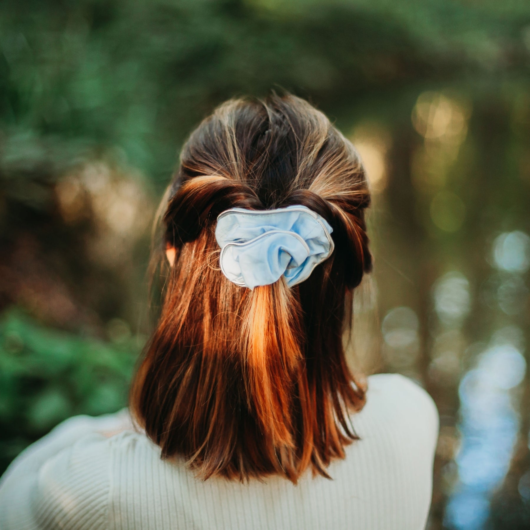FEMME VUE DE DOS PORTANT UN CHOUCHOU CHEVEUX FAIT MAIN BLEU CIEL EN COTON BIOLOGIQUE