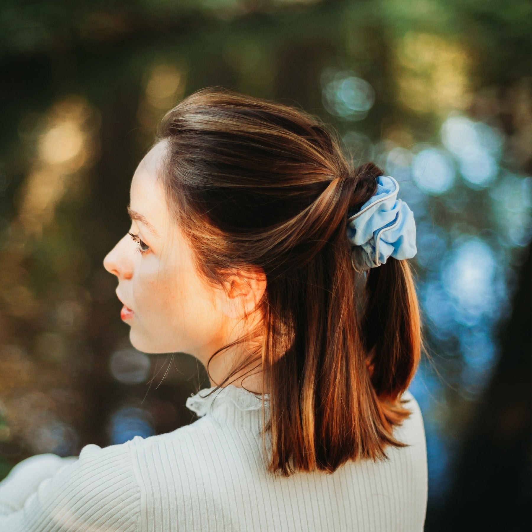 FEMME VUE DE PROFIL PORTANT UN CHOUCHOU BLEU CIEL EN COTON BIOLOGIQUE
