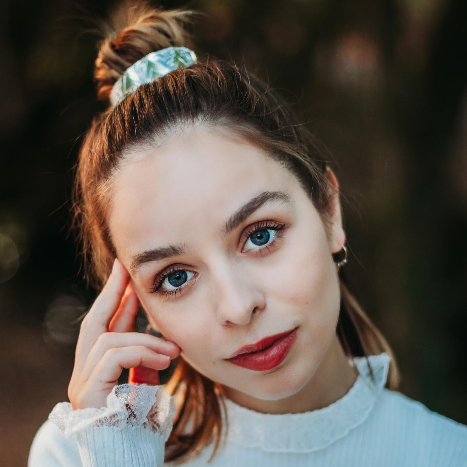 FEMME PORTANT UN CHIGNON ORNE D'UNE MANCHETTE ARGENTEE
