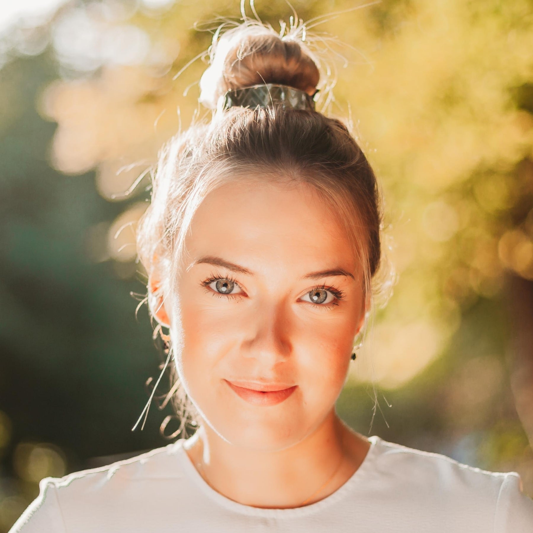 FEMME BLONDE PORTANT UN CHIGNON ORNE D'UNE MANCHETTE DOREE