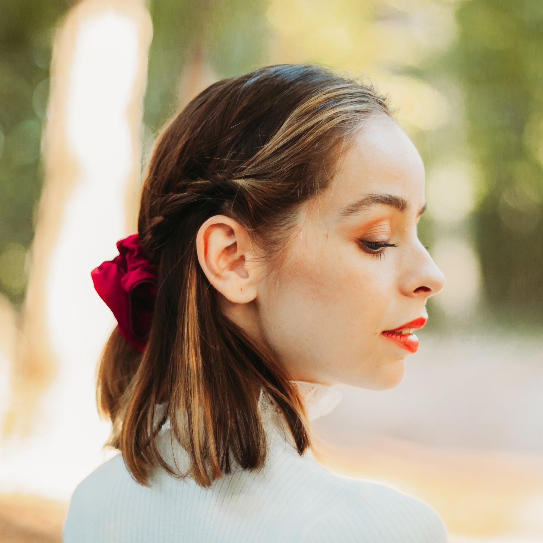 FEMME DE PROFIL PORTANT UN CHOUCHOU ROUGE EN COTON BIOLOGIQUE MADE IN FRANCE