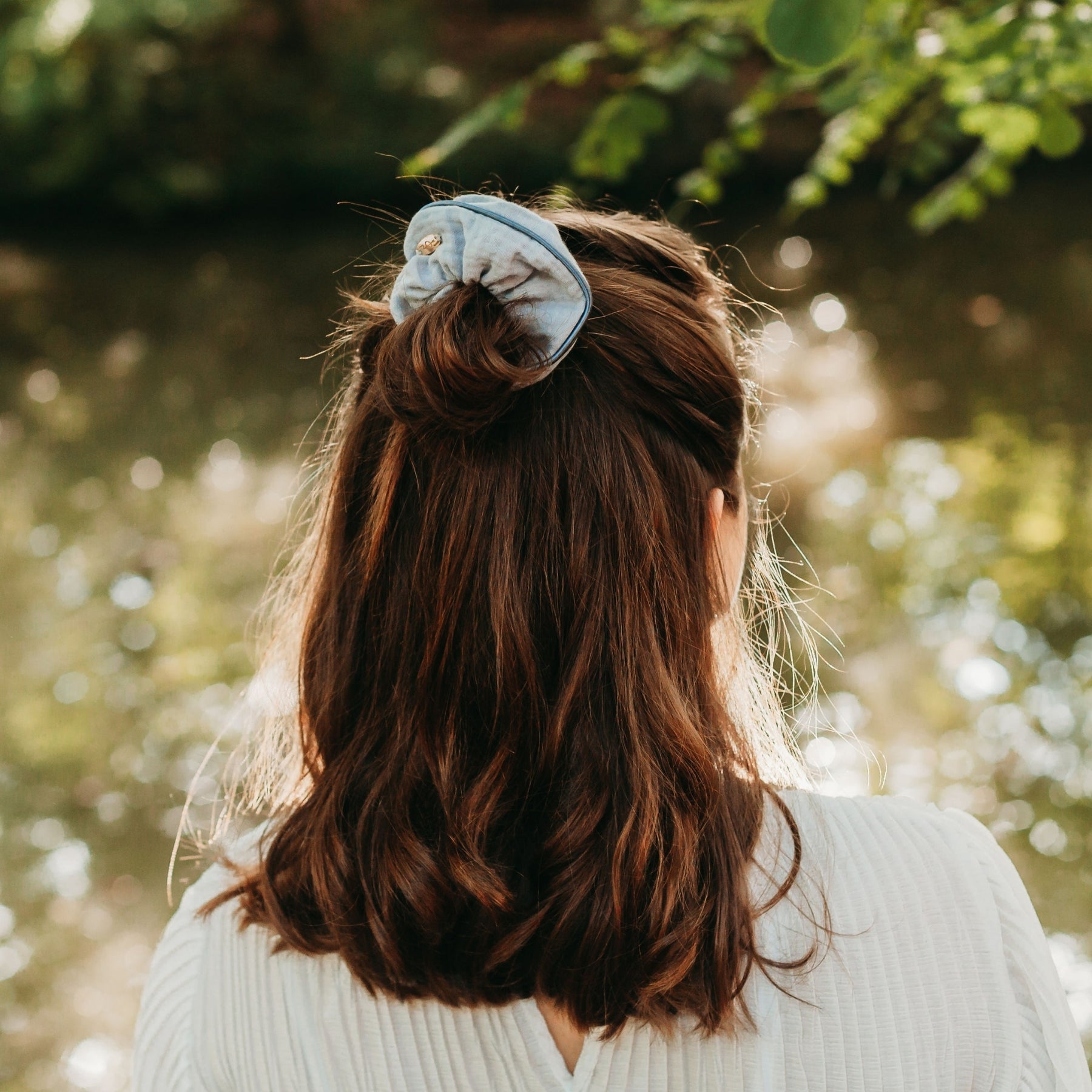 FEMME DE DOS PORTANT UN CHOUCHOU TENDANCE GRIS EN COTON BIOLOGIQUE