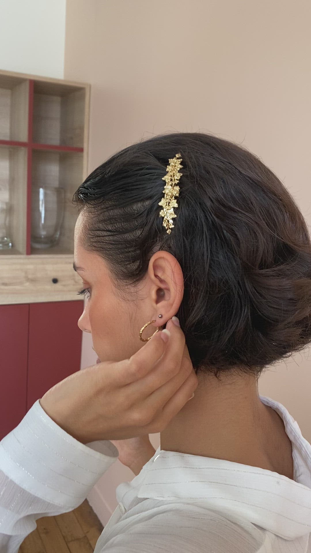 Femme cheveux courts décorés d'une petite barrette bijou dorée fleurie 