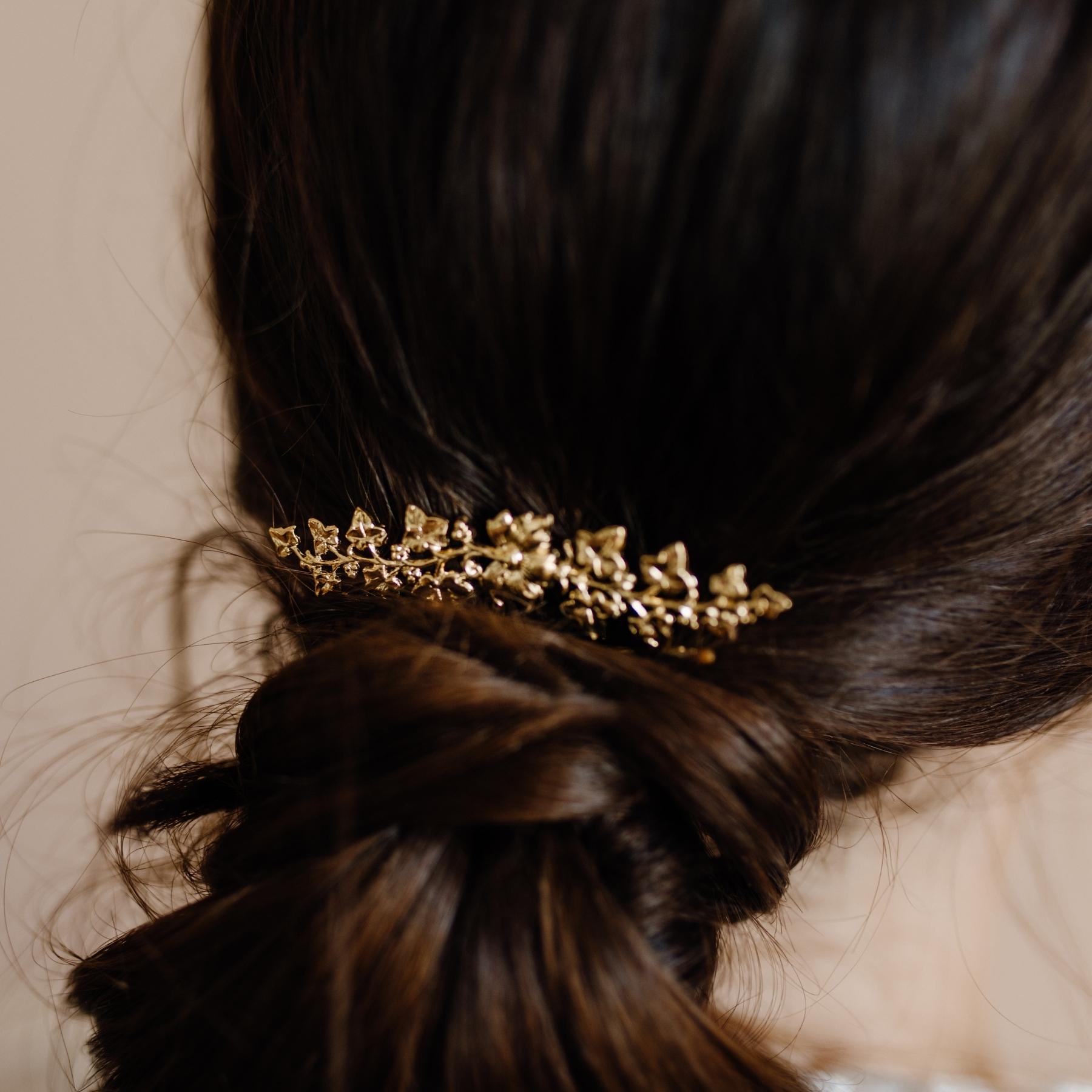 Chignon mariage décoré d'un pic à cheveux doré fleuri