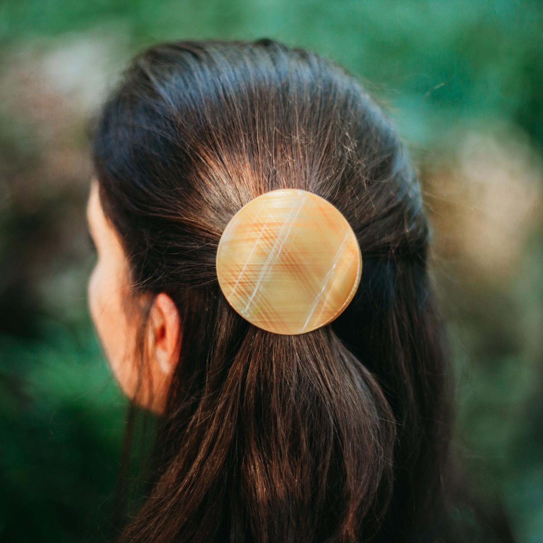 femme cheveux longs attaches avec pince plate ronde dorée originale 